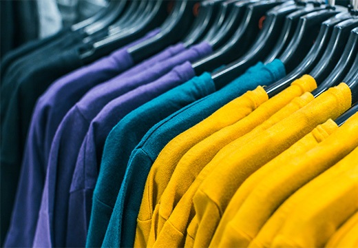 verschillende t shirts in verschillende kleuren aan een kledingrek