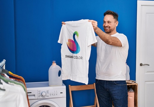 vrolijke man met een bedrukt shirt in zijn handen