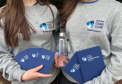 Twee meiden die bedrukte notitieboekjes en een bedrukte fles vasthouden en een sweater met logo aan hebben.