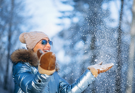vrouw geniet van de sneeuw in de winter